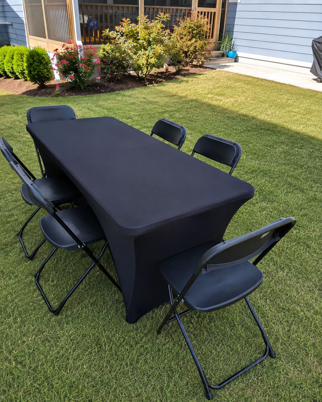 Black table and folding chair rental setup with complimentary linen